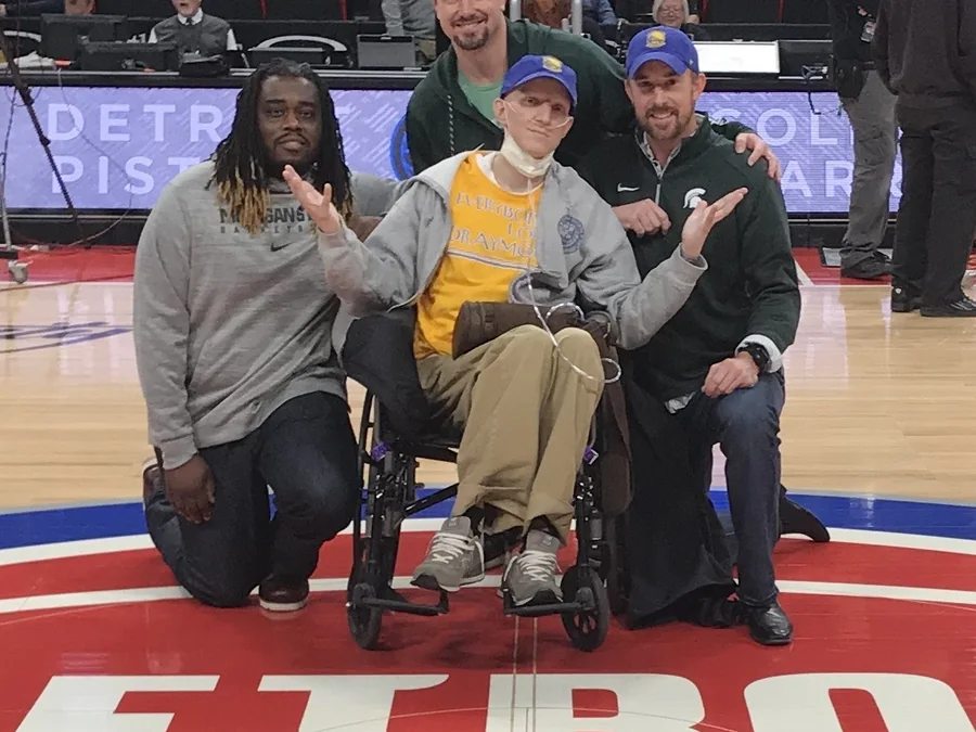 A One More Moment recipient sharing time with supporters at a basketball arena
